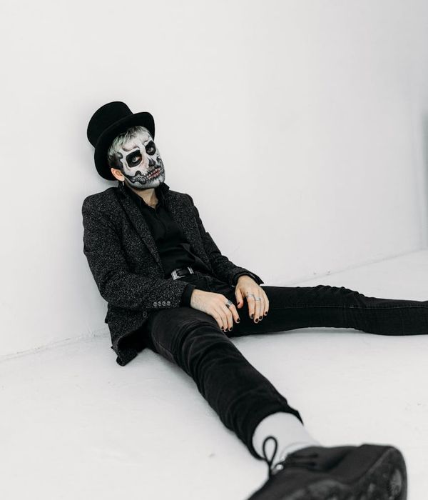 Man performing a controlled bodyweight exercise in a minimalist dark room.